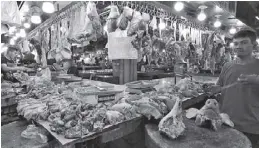  ??  ?? Vendors sell pork at the Commonweal­th Market in Quezon City yesterday.