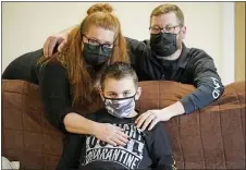  ?? RICK BOWMER — THE ASSOCIATED PRESS ?? Cooper Wuthrich, center, poses for a photograph with his mother Dani and father Kale at the truck stop his family partly owns Tuesday, Dec. 15, 2020, in Montpelier, Idaho.