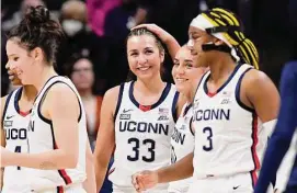  ?? Jessica Hill/Associated Press ?? UConn’s Nika Muhl (10) pats the head of teammate Caroline Ducharme (33) after Muhl broke the all time season assist record with a pass to Ducharme on Feb. 27.