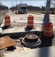  ?? RICHARD PAYERCHIN — THE MORNING JOURNAL ?? A sewer cover sits surrounded by orange warning barrels south of the intersecti­on of Lear-Nagel and Center Ridge roads in North Ridgeville on March 29.