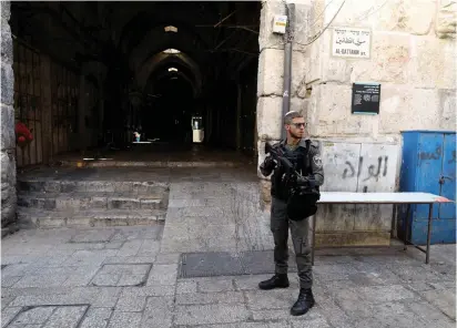  ??  ?? A BORDER POLICE officer secures an entrance to the Temple Mount in July.