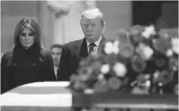  ?? Associated Press ?? ■ President Donald Trump and first lady Melania Trump pay their respects to former President George H. W. Bush on Monday as he lies in state in the Rotunda of the U.S. Capitol in Washington.
