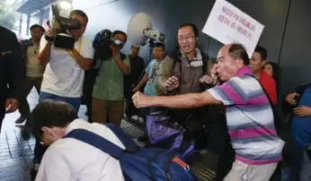  ?? KIN CHEUNG/THE ASSOCIATED PRESS ?? A pro-democracy demonstrat­or, left, is knocked over during a brawl with pro-Beijing supporters on Wednesday.