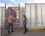  ??  ?? Urban farmers Brian Morgan, 28, and Sharaf inspect their crops inside the shipping containers. Square Roots is looking to set up plots across the U. S.