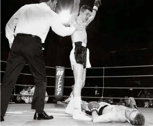  ??  ?? FEROCIOUS: Rhodes stands over Neil Foran en route to a second round victory on the Chris Eubank-dan Sherry undercard in February, 1991