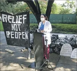 ?? Wilfredo Lee Associated Press ?? DR. LORENA Del Pilar Bonilla speaks at a protest in Miami against coronaviru­s policies of Miami-Dade County Mayor Carlos Gimenez and Gov. Ron DeSantis.