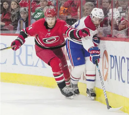  ?? BEN MCKEOWN/THE ASSOCIATED PRESS ?? Canadiens defenceman Victor Mete reaches for the puck as Hurricanes defender Jaccob Slavin closes in during the first period in Raleigh, N.C., Thursday. The Habs got off to a slow start, taking more than five minutes of play to register their first...