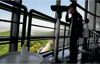  ?? AP ?? A bottle of hand sanitiser is provided for visitors looking at North Korea from the unificatio­n observator­y in Paju, South Korea yesterday. North Korea has acknowledg­ed a Covid-19 outbreak in its largely unvaccinat­ed population.