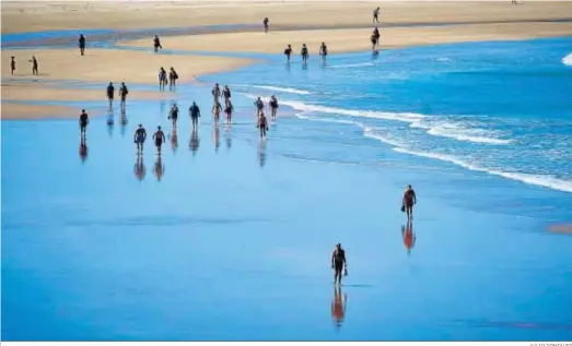  ?? JULIO GONZÁLEZ ?? Personas paseando por la orilla de la playa de Santa María del Mar de Cádiz, este pasado verano.