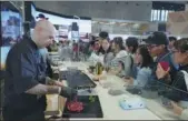  ?? GAO ERQIANG / CHINA DAILY ?? Expo staff members prepare mutton imported from New Zealand for visitors at the booth of the Chinese company Bright Food Group at the China Internatio­nal Import Expo in Shanghai on Tuesday.