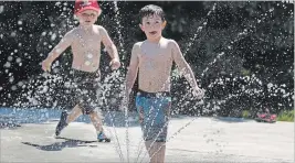  ?? CLIFFORD SKARSTEDT EXAMINER ?? Schoolchil­dren from St. Anne School beat the heat during the grand opening of the Barnardo Park Splash Pad on Tuesday.