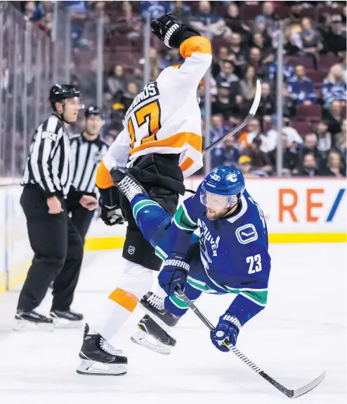  ?? DARRYL DYCK/CP ?? Defenceman Alex Edler crashes to the ice after colliding with Wayne Simmonds of the Flyers earlier this season. In his 13th season with the Canucks, Edler is playing at a high level and has emerged as a team leader.