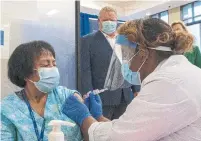  ?? FRANK GUNN THE CANADIAN PRESS FILE PHOTO ?? A nurse administer­s a vaccine shot to a personal support worker in Toronto last month. Premier Doug Ford’s government is funding tuition for personal support worker programs.