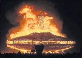  ?? Andy Barron Reno Gazette-Journal ?? THE “MAN” burns atop a UFO at 2013’s Burning Man festival. The festival’s temple, meant for mourning, amasses messages all week before it too is burned.