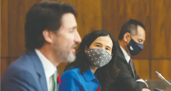  ?? ADRIAN WYLD / THE CANADIAN PRESS ?? Canada's Chief Public Health Officer Theresa Tam and Deputy Chief Public Health Officer Howard Njoo don masks as they listen to Prime Minister Justin Trudeau speak Friday.