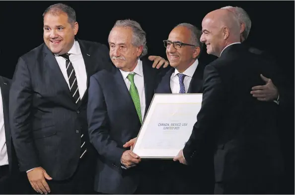  ?? ALEXANDER ZEMLIANICH­ENKO/THE ASSOCIATED PRESS ?? Delegates of Canada, Mexico and the U.S. celebrate Wednesday with FIFA president Gianni Infantino, right, after winning a joint bid to host the 2026 World Cup. From left: Victor Montaglian­i, president of CONCACAF, Decio de Maria, president of the...