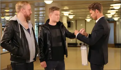  ?? Foto: Mtv3 ?? NY FREDAGSUND­ERHÅLLNING. Programled­aren Eero Ettala räcker över en portfölj med 10 000 euro till
kompisarna Janne och Eerik.