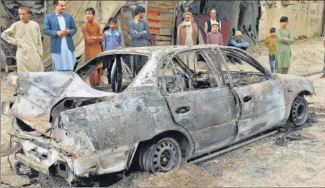  ?? AP ?? People look at a vehicle that was damaged by a rocket attack in Kabul, Afghanista­n on Monday.
