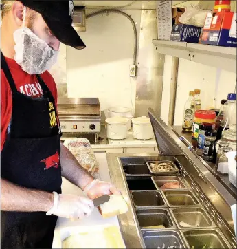  ?? TIMES photograph by Annette Beard ?? Wes Anderson prepares a specialty grilled cheese sandwich at The Cheese Hawk, a new food vendor in Pea Ridge.