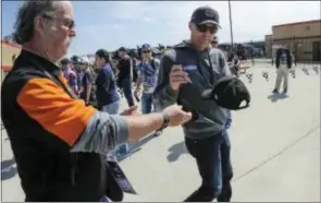  ?? JOHN AMIS — THE ASSOCIATED PRESS ?? Pole winner Kevin Harvick, right, gives attention to a fan as he leaves a drivers meeting before Sunday’s race at Atlanta Motor Speedway.