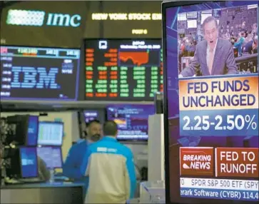  ?? Drew Angerer Getty Images ?? ON THE FLOOR of the New York Stock Exchange, a monitor displays the news after Fed policymake­rs voted unanimousl­y to keep their short-term interest rate steady and signaled there will be no rate hikes until 2020.
