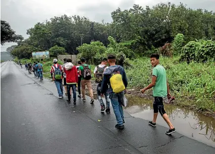  ?? AP ?? Honduran migrants walk along a highway in Cocales, Guatemala, on their way to the US border yesterday.