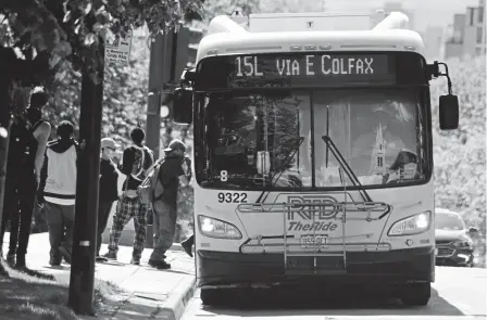  ??  ?? People board the RTD 15L bus at the East Colfax Avenue and Grant Street stop on Friday.