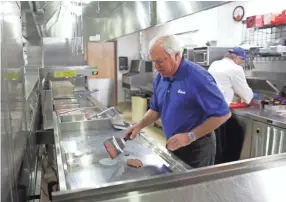  ?? DANNY DAMIANI/USA TODAY NETWORK-WISCONSIN ?? Craig Culver, Culver’s co-founder, demonstrat­es how to make a Culver’s ButterBurg­er at the company's headquarte­rs in Prairie du Sac, Wis.