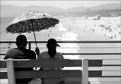  ?? AP Photo/Marcio Jose Sanchez ?? In this July 12 file photo, visitors sit on a bench on the pier amid the coronaviru­s pandemic in Santa Monica, Calif.