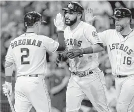  ?? Melissa Phillip / Houston Chronicle ?? Marwin Gonzalez, center, gets pats on the front and back from Alex Bregman and Brian McCann after hitting his Astros-best eighth homer Wednesday night.