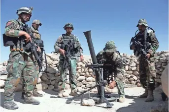  ?? GETTY IMAGES ?? Afghan commandos prepare to launch mortar shells on an Islamic State militant stronghold Friday in eastern Afghanista­n, where the U.S. military’s largest non-nuclear bomb hit mountain hideouts on Thursday.