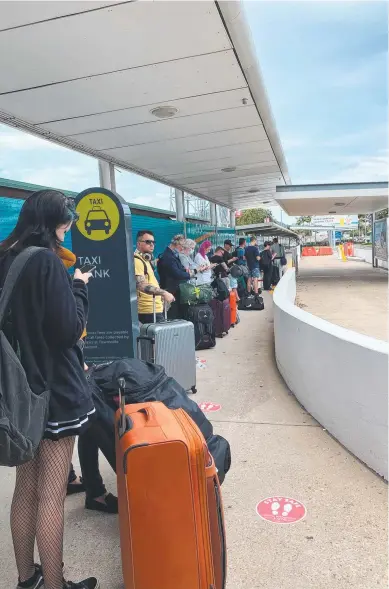  ??  ?? WAITING, WAITING: People queue at the Townsville Airport for cabs on Sunday.