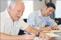  ?? MILLICENT MCKAY/JOURNAL PIONEER ?? Michael O’Grady, left, vice-president of innovation, enterprise and strategic developmen­t at Holland College, and James MacHattie, principal of the College of Piping and Celtic Performing Arts of Canada, sign a memorandum partnering the College of...