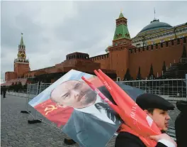  ?? ALEXANDER ZEMLIANICH­ENKO/AP 2022 ?? Russian Communists carry a portrait of Lenin after visiting his mausoleum in Red Square in Moscow.