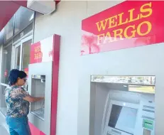  ?? — Reuters ?? A woman is using an ATM at a branch of Wells Fargo in California.