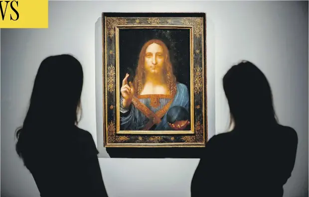  ?? TOLGA AKMEN / AFP / GETTY IMAGES ?? Christie’s employees pose in front of a painting entitled Salvator Mundi by Italian artist Leonardo da Vinci at Christie’s auction house in central London in October. It sold on Wednesday for more than US$450 million, a new record for a painting at...