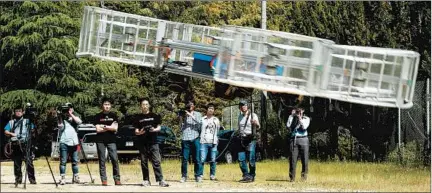  ?? KOJI UEDA/AP ?? Tsubasa Nakamura, project leader of Cartivator, third from left, watches a test of a prototype flying car in Japan. Cartivator is a Toyota-backed startup.