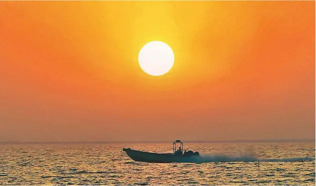  ?? Kamal Kassim / Gulf Today ?? ↑
The people on the boat are observing the unmatched beauty of the rising sun from close.