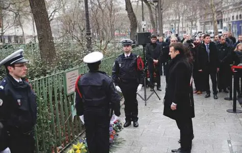  ?? AP ?? President Emmanuel Macron observes a minute of silence in front of the plaque commemorat­ing late police officer Ahmad Merabet to mark the third anniversar­y of the attack, in Paris yesterday.