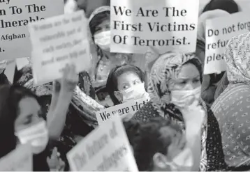  ?? MANISH SWARUP/AP ?? Afghan refugees mark Women’s Day in India: Afghan refugee women living in India hold placards during a demonstrat­ion Monday to mark Internatio­nal Women’s Day in New Delhi. The Afghan women were calling attention to their living conditions and requesting more support from the United Nations and the Indian government.