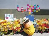  ?? THE ASSOCIATED PRESS ?? A makeshift memorial of flowers, candles and notes was started on the sidewalk outside the Los Feliz Trader Joe’s store in Los Angeles on Sunday.