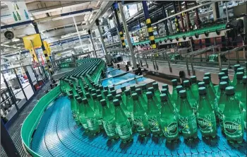  ?? BALINT PORNECZI / BLOOMBERG ?? Bottles of Perrier mineral water flow by at the company’s production line in the Nestle SA bottling plant in Vergeze, France. The company is looking to expand its market in China.