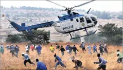  ?? PICTURE: CHRIS COLLINGRID­GE ?? A police helicopter flies low and scatters a crowd of foreigners at the Kya Sands squatter camp in June 2008. A standoff had developed between immigrants and a group of South Africans living in the squatter camp. Xenophobic attacks swept across Gauteng.