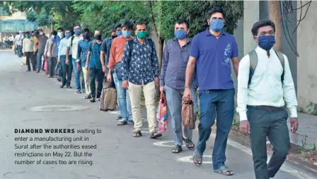  ??  ?? DIAMOND WORKERS waiting to enter a manufactur­ing unit in Surat after the authoritie­s eased restrictio­ns on May 22. But the number of cases too are rising.