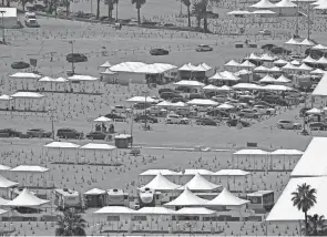  ?? DAMIAN DOVARGANES/AP ?? Motorists wait to receive a COVID-19 vaccine at Dodger Stadium in Los Angeles. A vaccine being tested by the Walter Reed Army Institute of Research might serve as a booster regardless of which vaccine a recipient gets.