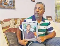  ?? JIM RASSOL/SUN SENTINEL 2017 ?? Clinton Jones Sr. holds a portrait of his son Corey, who was fatally shot in 2015 by Palm Beach Gardens police Officer Nouman Raja.