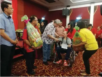  ??  ?? Awang Tengah presents CNY goodies to a special needs recipient.