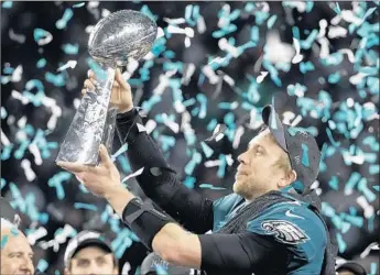  ?? Chris O'Meara Associated Press ?? PHILADELPH­IA’S Nick Foles holds the Vince Lombardi Trophy after the Eagles defeated New England, 41-33, to win the Super Bowl, their first NFL championsh­ip since 1960. He was named the MVP.