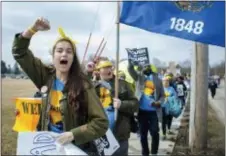  ?? ANGELA MAJOR — THE JANESVILLE GAZETTE VIA AP ?? Bea Millan-Windorski, left, raises her fist at drivers in passing vehicles who honked their horns Wednesday as marchers make their way to Traxler Park for the 50 Miles More rally in Janesville, Wis.