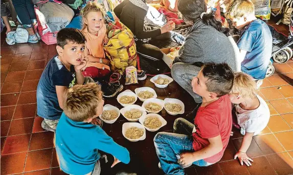  ?? FOTO MAFRA – MICHAL RŮŽIČKA ?? Večeře na zemi. Uprchlíci na pražském hlavním nádraží (v poslední době hlavně Romové, ale nejen oni) dostávají od dobrovolní­ků jídlo třikrát denně.
